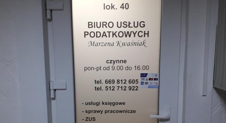 Tablica informacyjna na drzwiach Biura Usług Marzena Kwaśniak